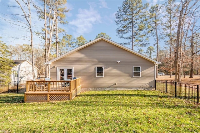 rear view of property featuring french doors, a deck, and a lawn