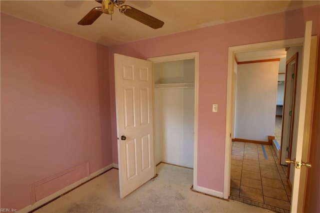 unfurnished bedroom with ceiling fan and a closet