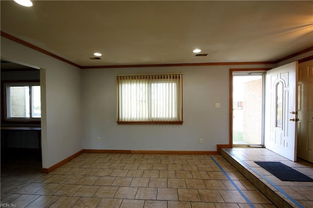 tiled foyer with crown molding and a healthy amount of sunlight