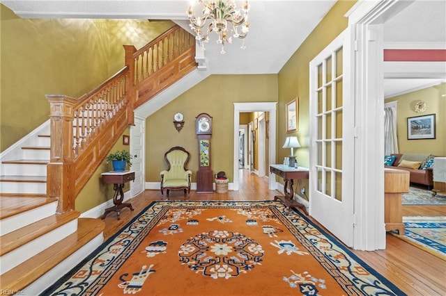 entryway with hardwood / wood-style floors and a notable chandelier