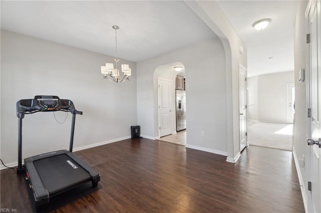 workout area with dark hardwood / wood-style floors and a chandelier