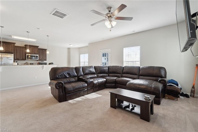 carpeted living room featuring ceiling fan