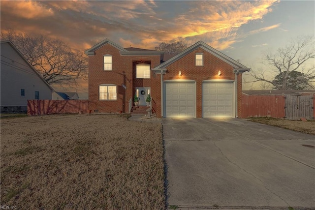 front facade featuring a garage and a yard