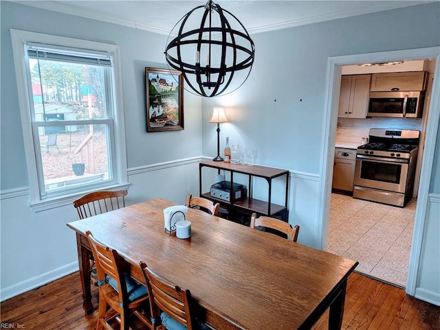 dining area with ornamental molding and light wood-type flooring