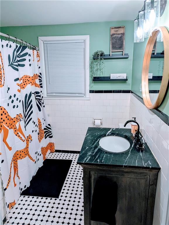 bathroom featuring vanity and tile walls