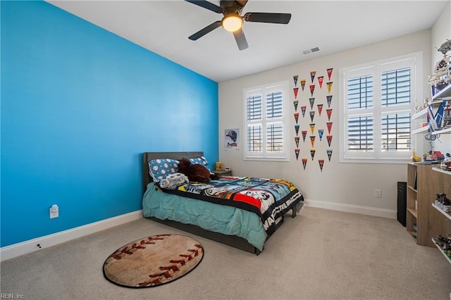 bedroom featuring multiple windows, light colored carpet, and ceiling fan