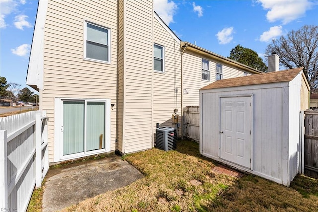 back of property featuring a storage shed, central AC unit, and a yard