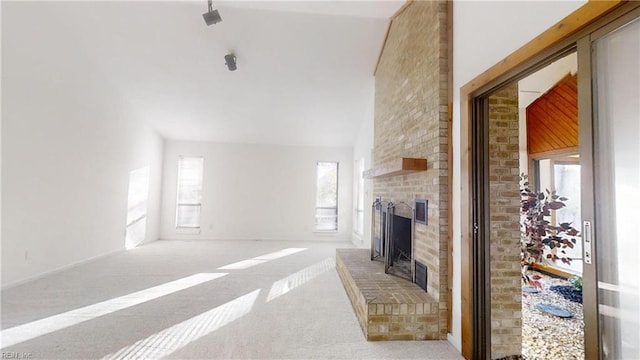 carpeted living area with a fireplace and high vaulted ceiling