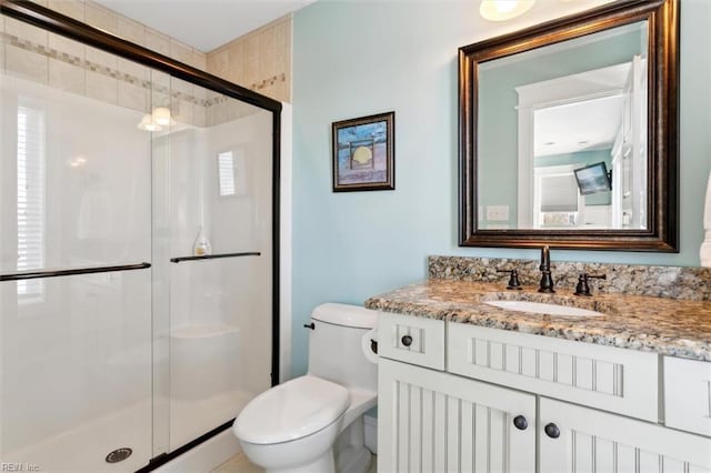 bathroom with vanity, toilet, and a shower with shower door