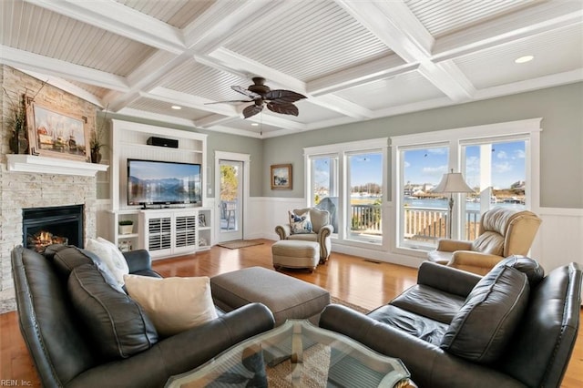 living room with coffered ceiling, a fireplace, beam ceiling, and light hardwood / wood-style flooring