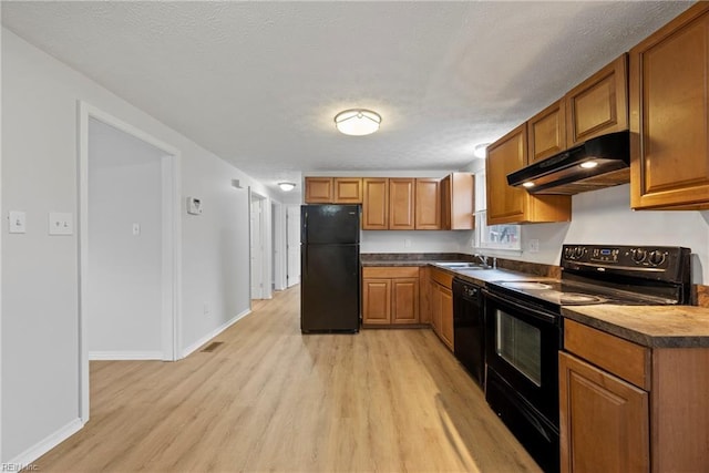 kitchen with a textured ceiling, sink, light hardwood / wood-style flooring, and black appliances