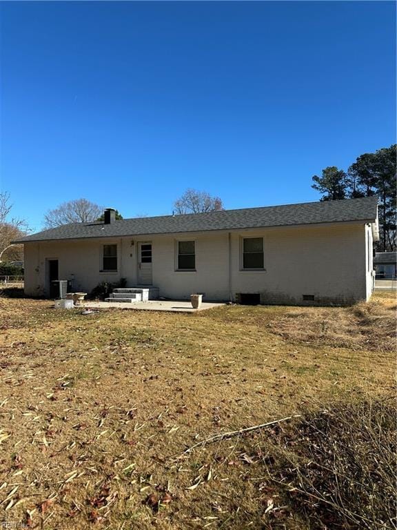 back of house with central AC, a patio area, and a lawn