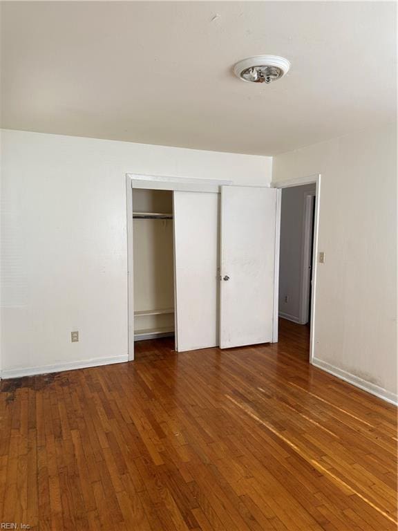 unfurnished bedroom featuring a closet and dark hardwood / wood-style floors