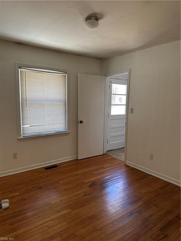 empty room with dark wood-type flooring