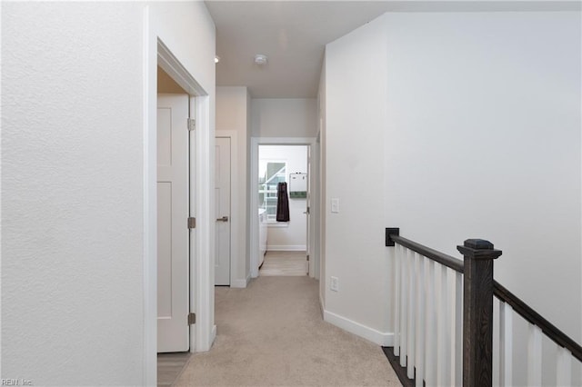 hallway featuring light colored carpet