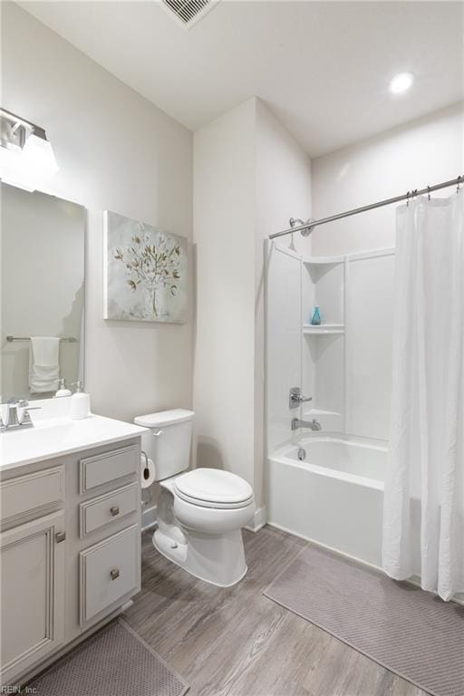 full bathroom featuring hardwood / wood-style flooring, vanity, shower / bathtub combination with curtain, and toilet