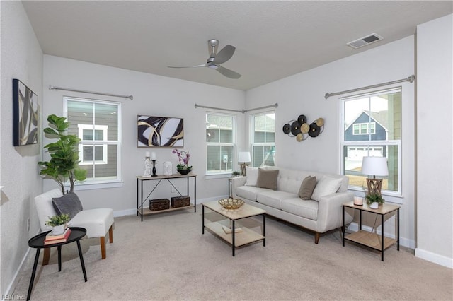 living room with ceiling fan, light colored carpet, and a healthy amount of sunlight