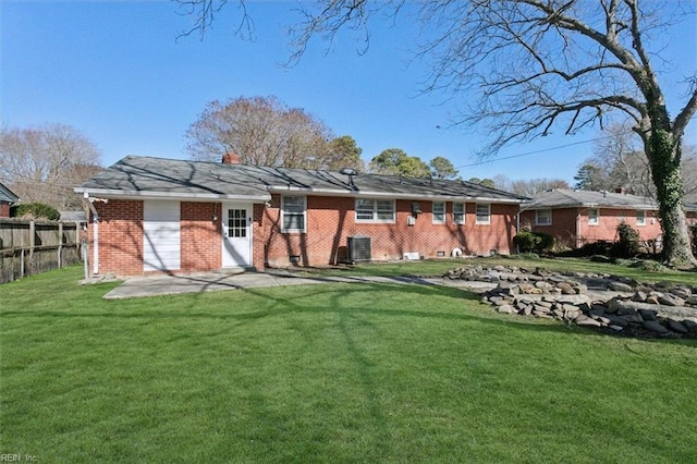 rear view of property with a yard, a patio area, and central air condition unit