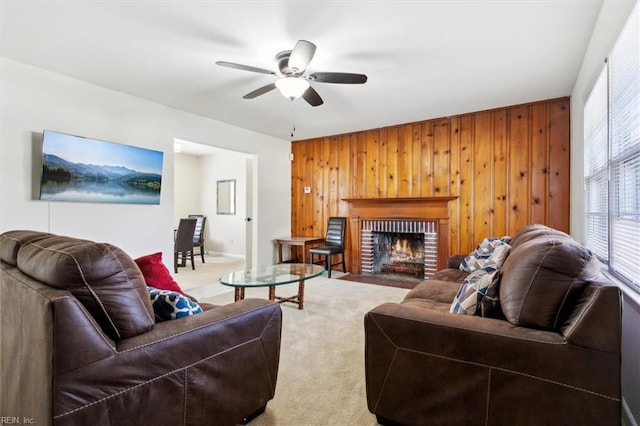 carpeted living room with a brick fireplace, ceiling fan, and wood walls