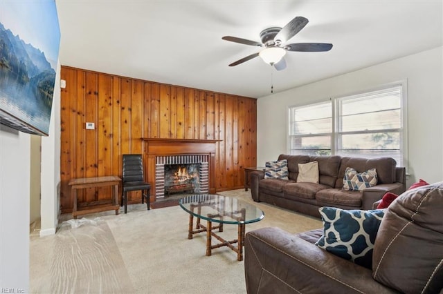 living room with light carpet, a fireplace, wooden walls, and ceiling fan