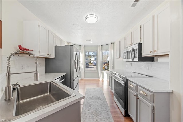 kitchen with white cabinetry, sink, decorative backsplash, and appliances with stainless steel finishes