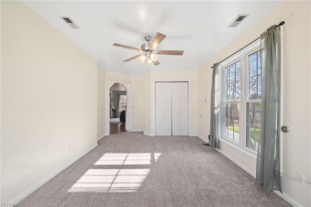 unfurnished bedroom with light colored carpet, ceiling fan, and a closet