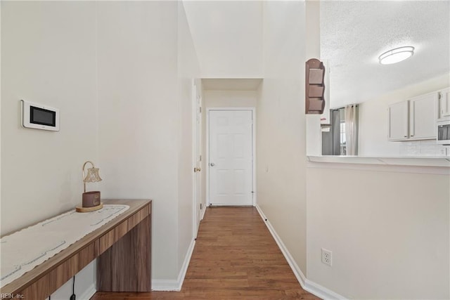 hallway featuring light hardwood / wood-style floors and a textured ceiling