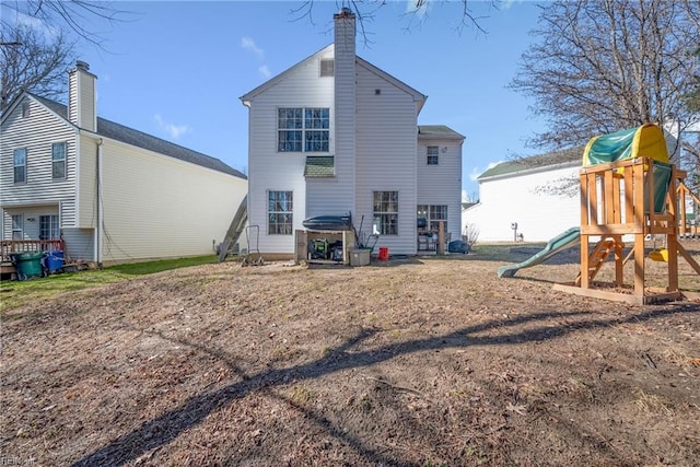 rear view of property featuring a playground