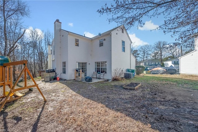 back of property with a playground and central air condition unit