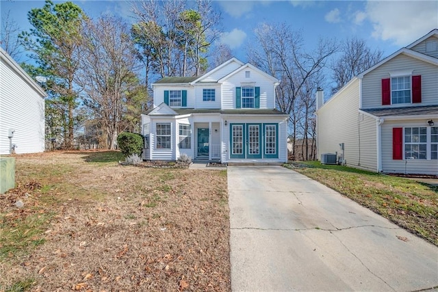 view of front property featuring central AC unit and a front yard