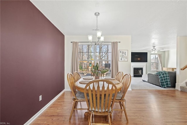 dining room featuring wood-type flooring and ceiling fan with notable chandelier