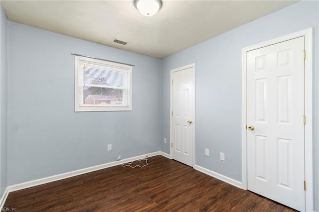 unfurnished bedroom with dark wood-type flooring