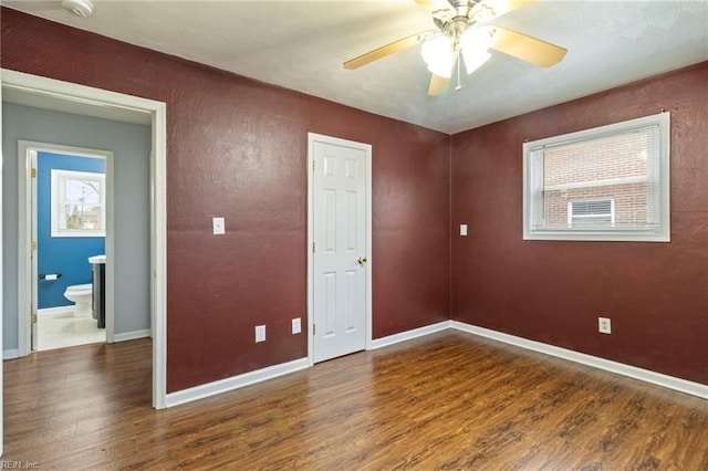 unfurnished bedroom with dark hardwood / wood-style flooring, a closet, and ceiling fan