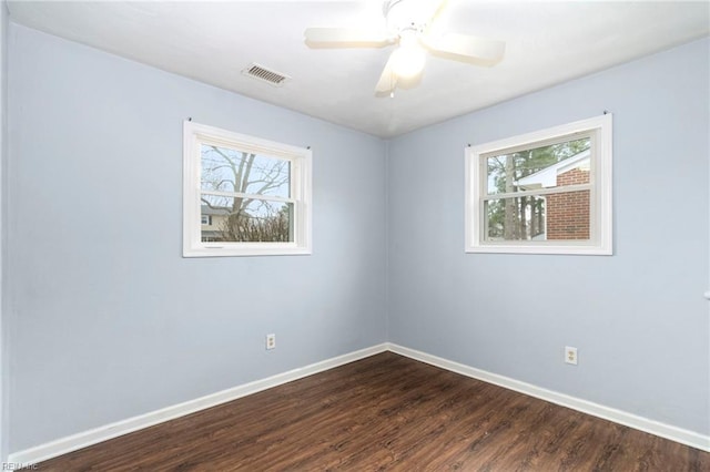 empty room featuring dark wood-type flooring, ceiling fan, and plenty of natural light