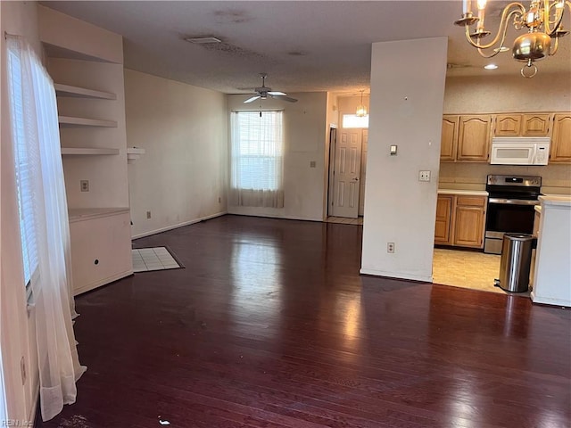 unfurnished living room featuring ceiling fan with notable chandelier and hardwood / wood-style floors