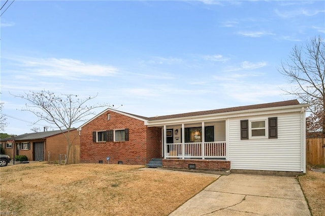 ranch-style house featuring covered porch and a front lawn