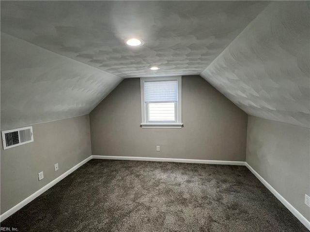 additional living space featuring vaulted ceiling and carpet