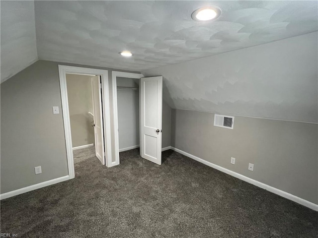 bonus room featuring dark carpet and vaulted ceiling