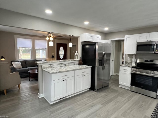 kitchen with white cabinetry, hanging light fixtures, kitchen peninsula, and appliances with stainless steel finishes