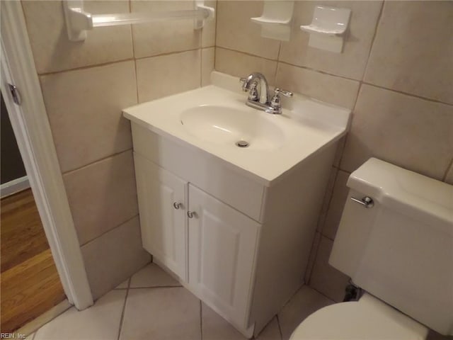 bathroom featuring tile walls, vanity, tile patterned floors, and toilet