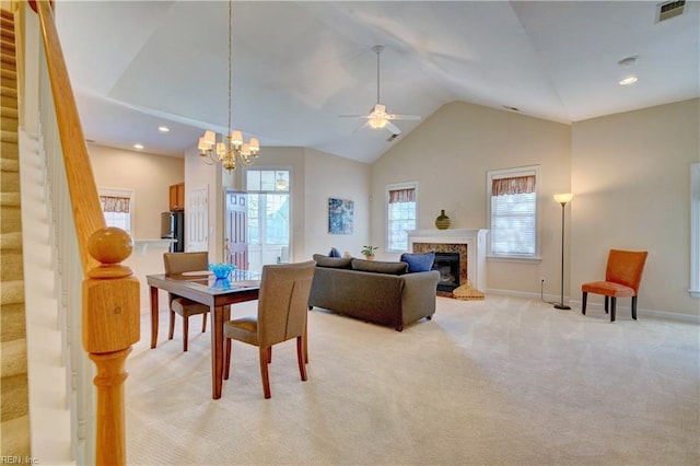 carpeted dining area featuring a chandelier and high vaulted ceiling