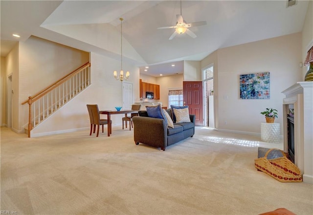 living room with light carpet, ceiling fan with notable chandelier, and high vaulted ceiling