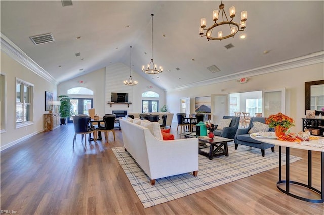 living room featuring a chandelier, high vaulted ceiling, and light wood-type flooring