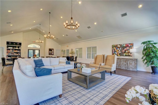 living room with crown molding, wood-type flooring, a chandelier, and high vaulted ceiling