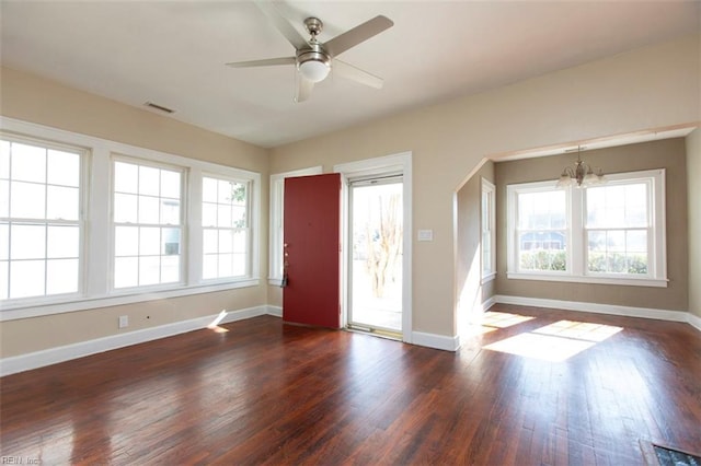 entrance foyer featuring a healthy amount of sunlight, dark hardwood / wood-style flooring, and ceiling fan with notable chandelier