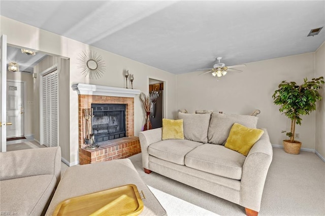 carpeted living room with a brick fireplace and ceiling fan