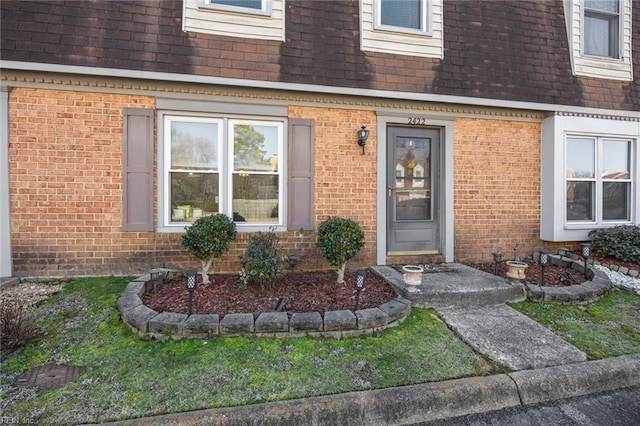 entrance to property featuring a lawn