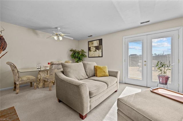 carpeted living room with french doors and ceiling fan