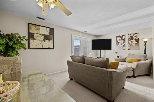 carpeted living room with ceiling fan