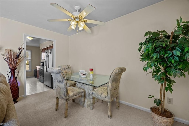 carpeted dining room featuring ceiling fan